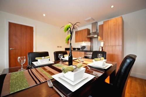 a dining room table with black chairs and a dining room at Arcadian Aparthotel in Birmingham