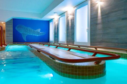 a swimming pool with a shark on the wall at Thalacap Île de Ré - Thalasso & Spa in Ars-en-Ré
