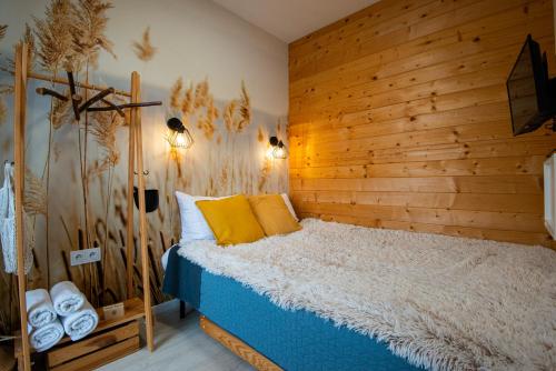 a bedroom with a bed with a wooden wall at Costa del Kryspi Całoroczne Domy na Wodzie in Cholerzyn