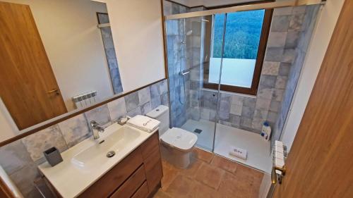 a bathroom with a sink and a toilet and a mirror at El Guitart - Turisme Rural in Ripoll