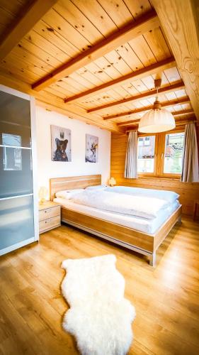 a bedroom with a large bed and a wooden ceiling at Bergquelle 1.OG Ost in Bettmeralp