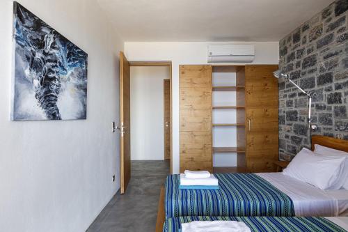 a bedroom with a bed and a wall with a picture at Lagremha Villa in Agios Pavlos
