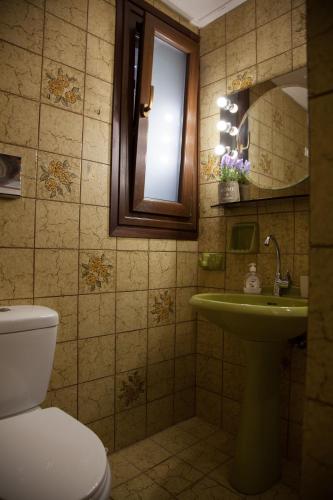 a bathroom with a toilet and a sink and a mirror at Moustakias Villa in Kefallonia
