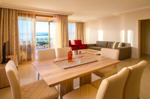 een woonkamer met een houten tafel en stoelen bij Luxury Apartments Villa Matea in Malinska