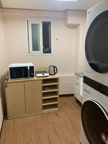 a living room with a tv and a microwave at Hngstay in Seoul