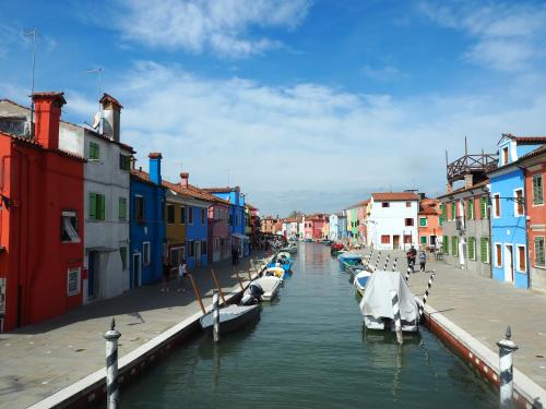 a group of boats in a canal with colorful buildings at Venice Luxury Watersdoor in Venice