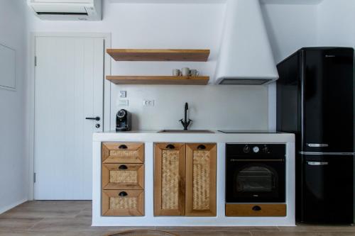 a kitchen with a sink and a black refrigerator at Arsenis Luxury Villas in Plaka