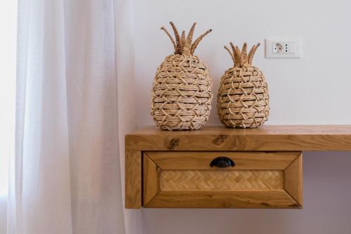 two pineapples sitting on top of a wooden shelf at Arsenis Luxury Villas in Plaka