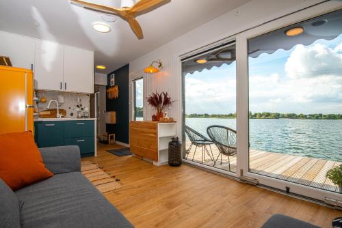a kitchen and a living room with a view of the water at Costa del Kryspi Całoroczne Domy na Wodzie in Cholerzyn