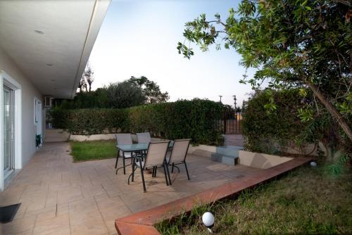 a patio with a table and chairs in a yard at SK-George Apartments by the Sea and Airport in Porto Rafti