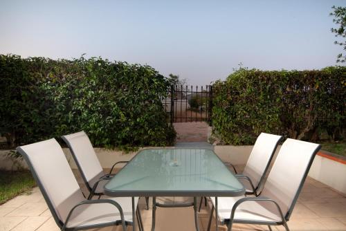 a table and chairs with a green table and a fence at SK-George Apartments by the Sea and Airport in Porto Rafti