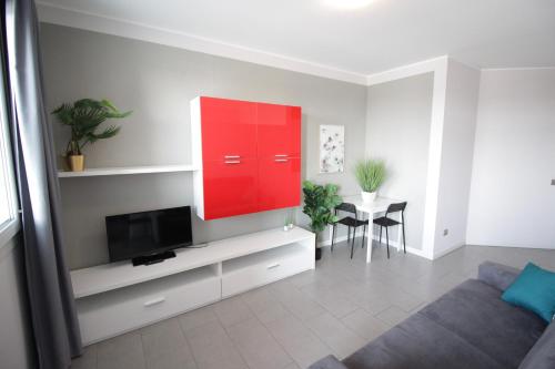 sala de estar con TV y armario rojo en The Residence Galliate, en Galliate