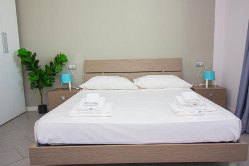 una camera da letto con un grande letto con lenzuola e cuscini bianchi di The Residence Galliate a Galliate