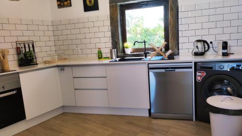 a kitchen with a sink and a washing machine at Pomar das Oliveiras - Private Swimming pool - Free EV Chrg - Pet Friendly in Carvalhal Cimeiro