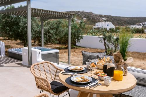 a table with plates of food on a patio at Arsenis Luxury Villas in Plaka