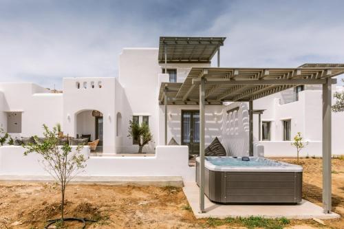 a white house with a hot tub in a yard at Arsenis Luxury Villas in Plaka