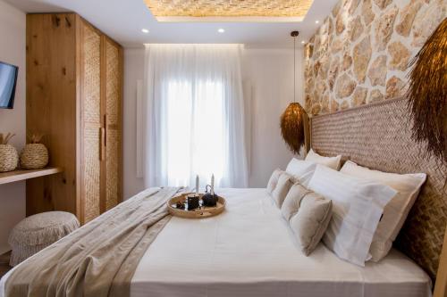 a bedroom with a large white bed and a window at Arsenis Luxury Villas in Plaka