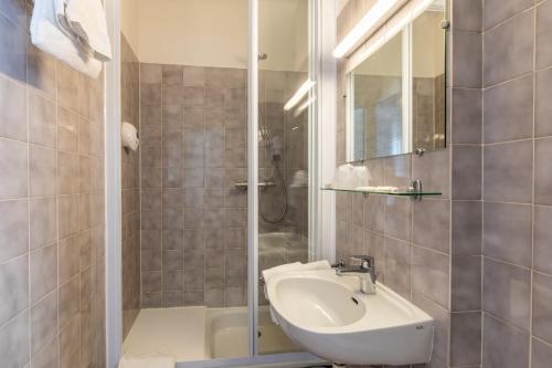 a bathroom with a sink and a shower at Atlantic Hotel Rennes Centre Gare in Rennes