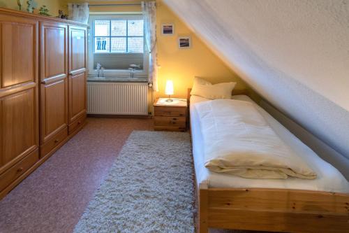 ein kleines Schlafzimmer mit einem Bett und einem Waschbecken in der Unterkunft Herta in Neßmersiel