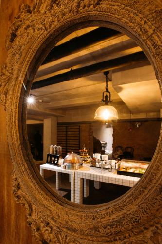 a mirror reflection of a table in a room at Urban Park Hotels in Tbilisi City