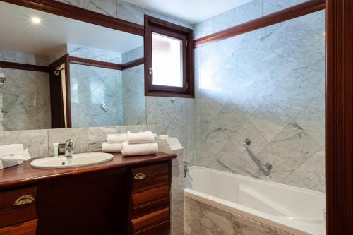 a bathroom with a sink and a tub and a shower at Hôtel La Gentilhommière in Nuits-Saint-Georges