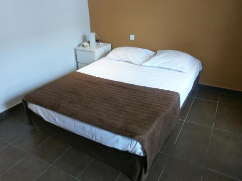 1 dormitorio con 1 cama grande con sábanas blancas en Hotel Restaurant La Frégate, en La Seyne-sur-Mer