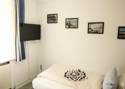 ein Wohnzimmer mit einem Sofa und einem Flachbild-TV in der Unterkunft Kapitänshaus Lassen - Zimmer Bounty in Westerland