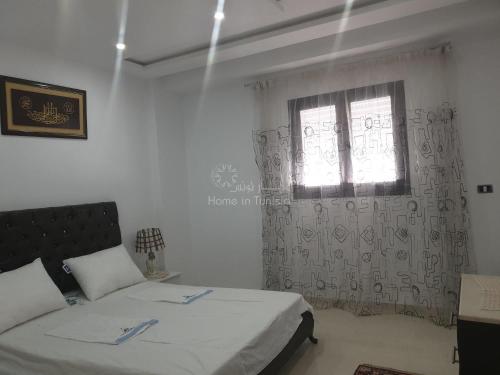 a bedroom with two beds and a window at appartement de vacance à corniche in Sousse