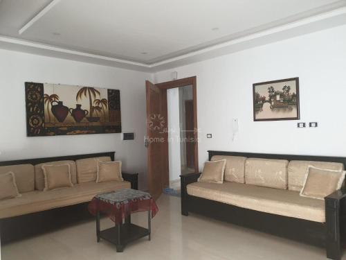a living room with two couches and a table at appartement de vacance à corniche in Sousse