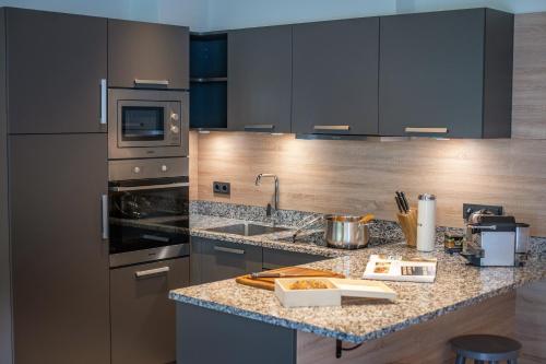 a kitchen with stainless steel appliances and a granite counter top at Sunny Ferienwohnungen Ski In - Ski Out - Self Check-in in Zell am See
