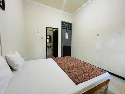 a bedroom with a white bed in a room at Langko 48 RedPartner in Tanjungkarang