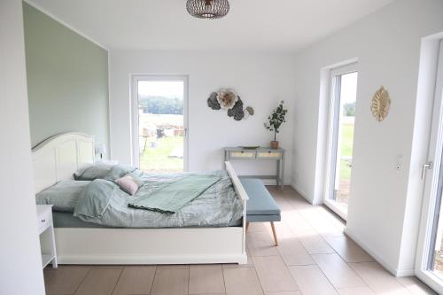 a white bedroom with a bed and a window at Auszeit mit Weitblick in der Sächsischen Schweiz - kleiner Bauernhof mit Tieren und Wallbox in Rathmannsdorf