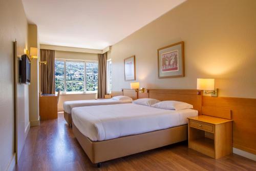 ein Hotelzimmer mit 2 Betten und einem Fenster in der Unterkunft Hotel Fundador in Guimarães