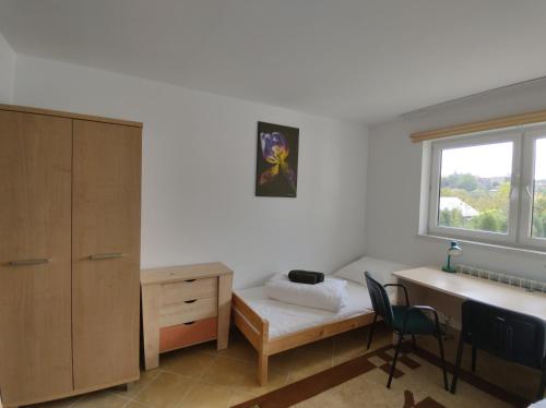 a bedroom with a bed and a desk and a window at Pokoje u Marii i Piotra in Brzozów