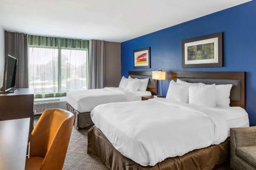 ein Hotelzimmer mit 2 Betten und einem TV in der Unterkunft Comfort Inn & Suites in Grand Blanc