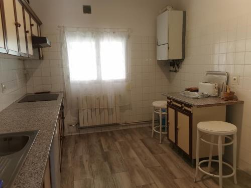 a kitchen with a counter and stools in it at Villa "Luna de Segovia" in Leganés