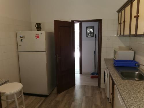 a kitchen with a white refrigerator and a sink at Villa "Luna de Segovia" in Leganés