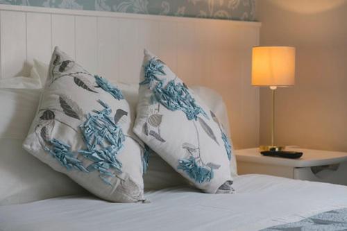 a bed with two blue and white pillows on it at Windsor Lodge B&B in Drogheda