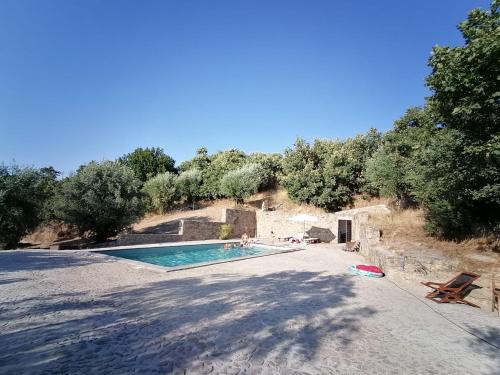 una piscina en medio de una colina con árboles en ALENTEJO Mountain Vacation House, en Castelo de Vide