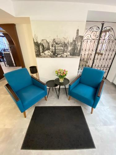 two blue chairs and a table in a room at Burghotel Nürnberg in Nürnberg