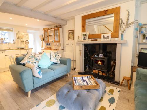 a living room with a blue couch and a fireplace at Cartrefle in Bala