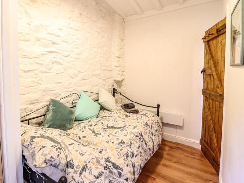 a bedroom with a bed and a stone wall at Cartrefle in Bala