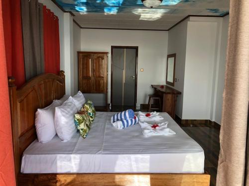 a bedroom with a bed with two towels on it at MT Seaside Apartment in La Digue