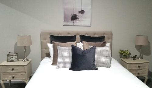 a bedroom with a bed with pillows and two night stands at Kennedy House Euroa PERFECT FOR SHORT TERM STAYS in Euroa