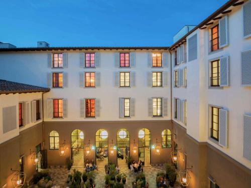 un gran edificio con gente sentada en el patio en 25hours Hotel Florence Piazza San Paolino, en Florencia