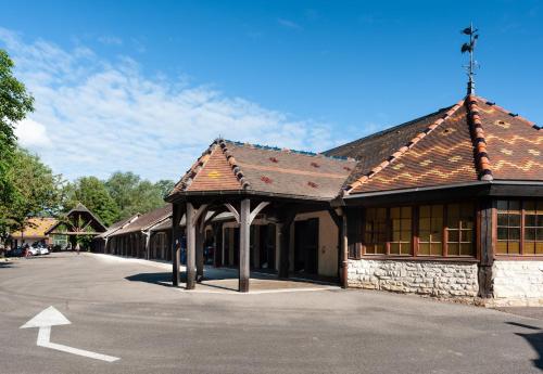 a building with a parking lot in front of it at Hôtel La Gentilhommière in Nuits-Saint-Georges
