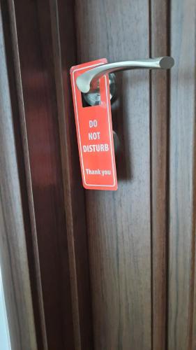 a do not disturb sign hanging on a door at Apartments Kojic in Bar