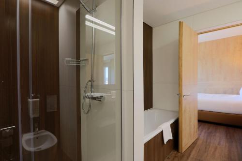 a bathroom with a shower and a sink and a toilet at Hotel Fundador in Guimarães