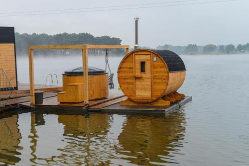 a wooden cabin on a dock in the water at Costa del Kryspi Całoroczne Domy na Wodzie in Cholerzyn