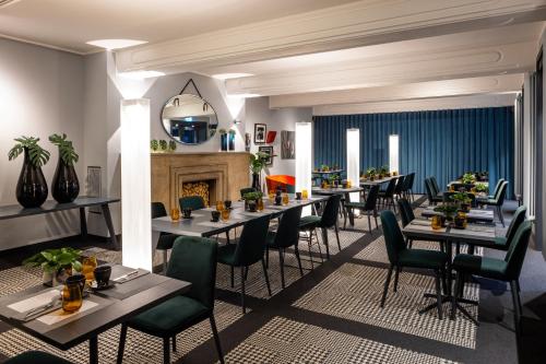 a dining room with tables and chairs and a fireplace at The Midtown Hotel in Cologne